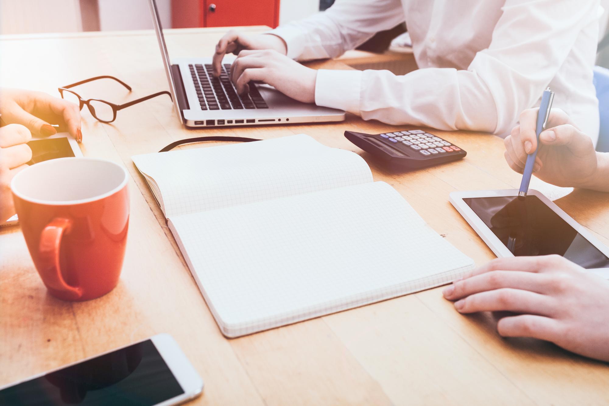 Beratungssitzung an einem Tisch mit Laptop und Notizen